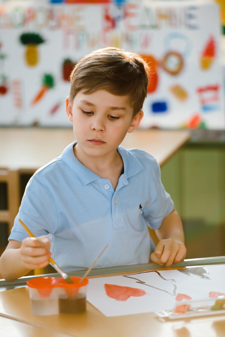 A young child concentrating on a hands-on activity at kinder